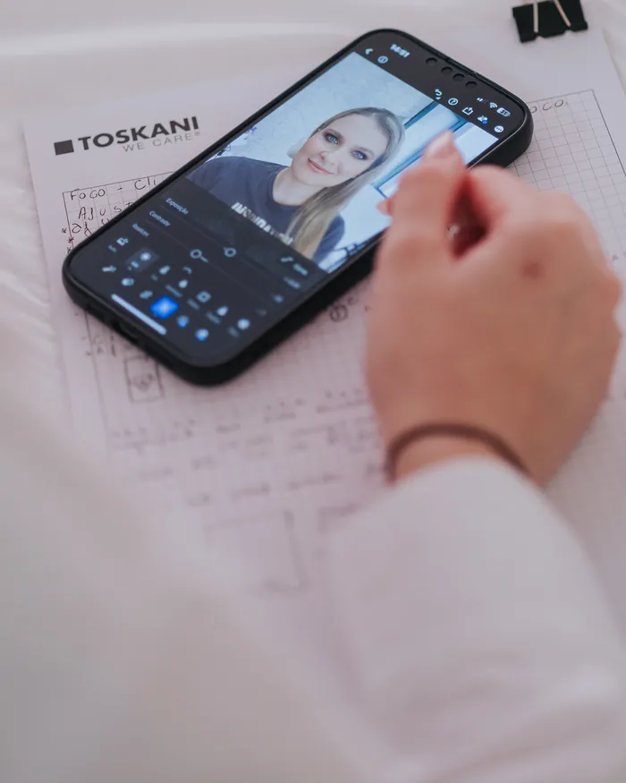 Um telemóvel a mostrar o retrato de uma cliente durante a edição.